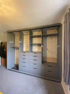Pearl grey wardrobe with lots of drawers and pulldown hanging rail making use of the vertical space, fitted in Kirk Merrington
